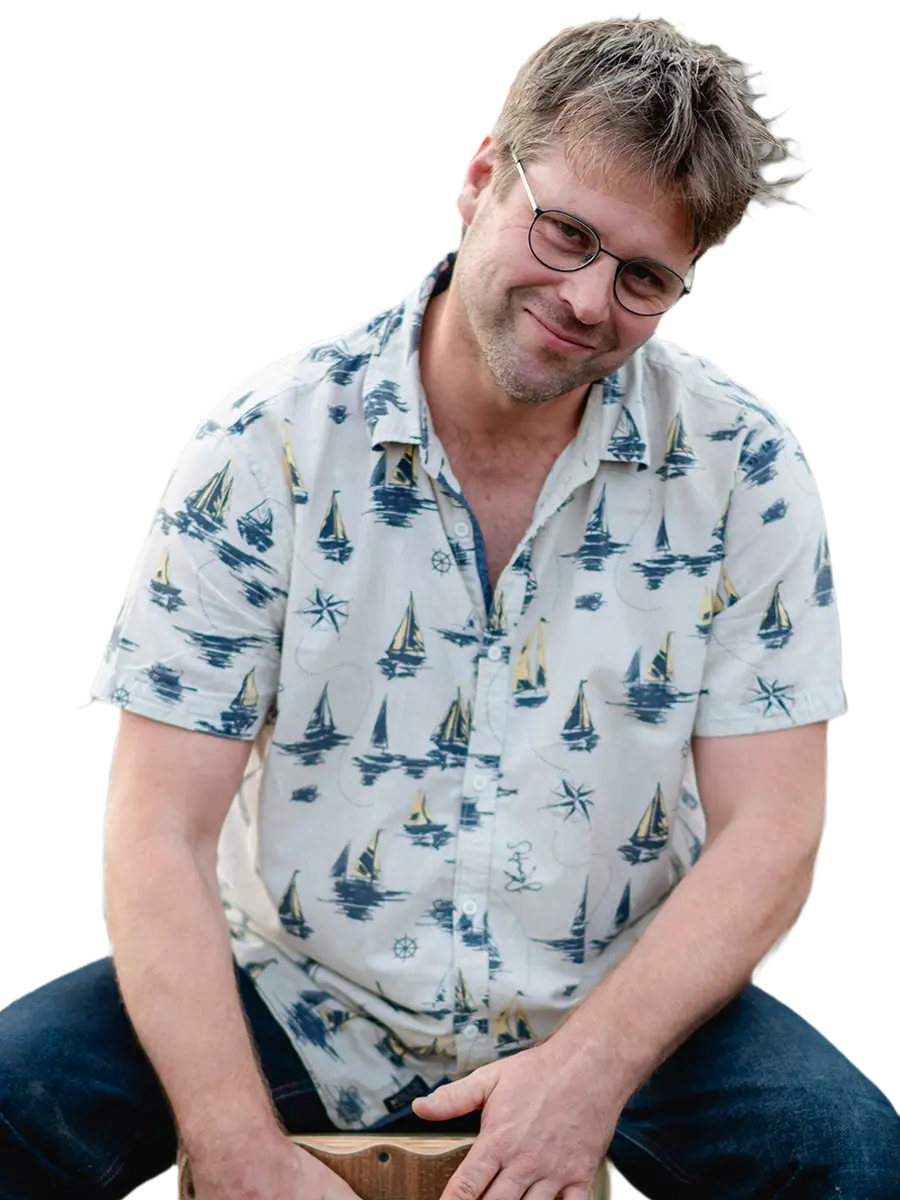 Basti Landsleitner, Cajon und Percussion bei famos., lächelnd im blau-weißen Hemd