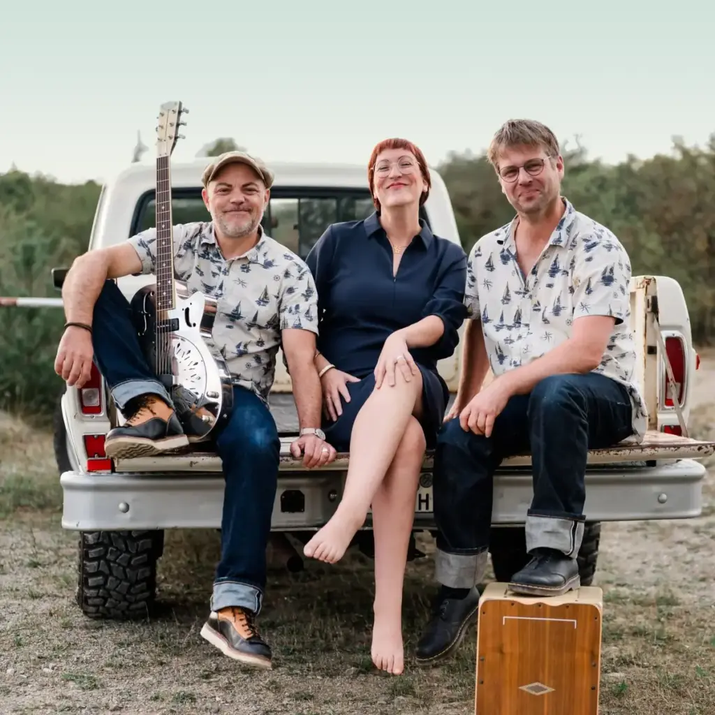famos. Trio auf der Ladefläche eines Pickups: Stephan Schmitt mit Gitarre, Conny Morath und Basti Landsleitner